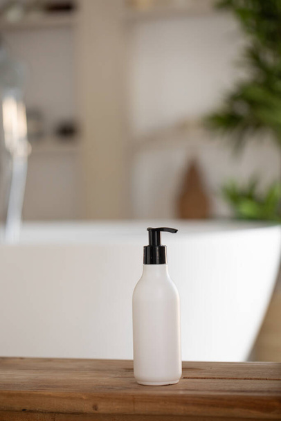 A mock-up of a white dispenser with cosmetics in front of the bathroom and a green tree. A template for a cream, shampoo or shower gel. - Foto, Imagen