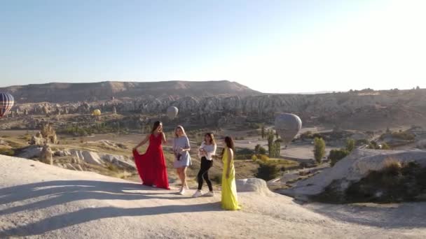 Mädchen beim Versuch, eine Champagnerflasche in Kappadokien zu öffnen. Heißluftballons im Hintergrund. Sonnenuntergang.Hochwertiges FullHD-Filmmaterial - Filmmaterial, Video