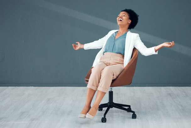 Sedia spensierata e mockup con una donna di colore che scivola sul pavimento del suo ufficio sentendosi libera dallo stress. Libertà, relax e successo con un'impiegata pazza che si siede sul posto di lavoro. - Foto, immagini