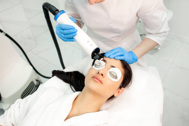 zákrok laserové stimulace růstu vlasů, lékař kosmetolog provádí zákrok proti vypadávání vlasů v kosmetické klinice s moderním vybavením - Fotografie, Obrázek