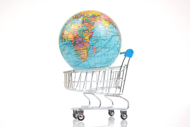 Земной шар в корзине с долларами на белом фоне. концепция продажи земельных ресурсов. по всему миру - Фото, изображение