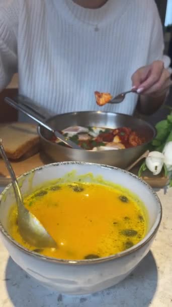 Cream of roasted pumpkin soup. Close-up view of person mixing ready pumpkin cream soup using spoon. Front view. Verticale video. 4k footage - Materiaali, video