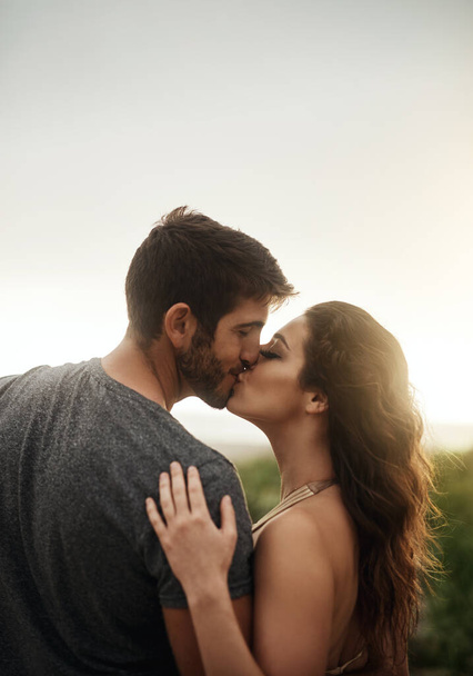 Verliebt sein ist der beste Ort, um zu sein. Rückansicht eines jungen Paares, das sich am Strand küsst - Foto, Bild