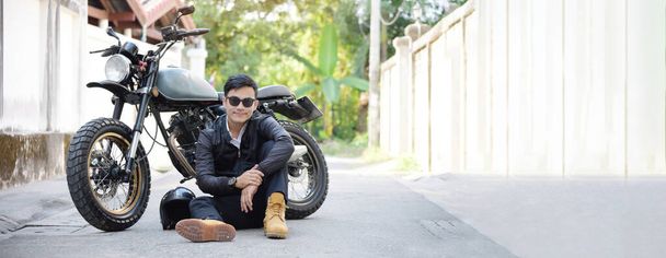 Banner Asian man motorbike in black leather jacket travel rider trip. Panorama Handsome Men wear sunglass outdoor lifestyle freedom rider. Hipster asian man hobby ride motor bike with copy space - Fotografie, Obrázek