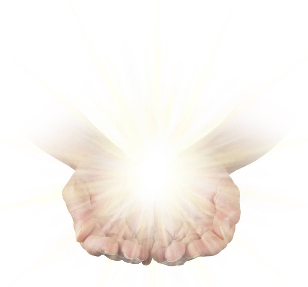 Sending you Pure Healing Energy - vrouwelijke open, samengeknepen handen geïsoleerd op witte achtergrond met daarboven een heldere gloeiende energiebol  - Foto, afbeelding