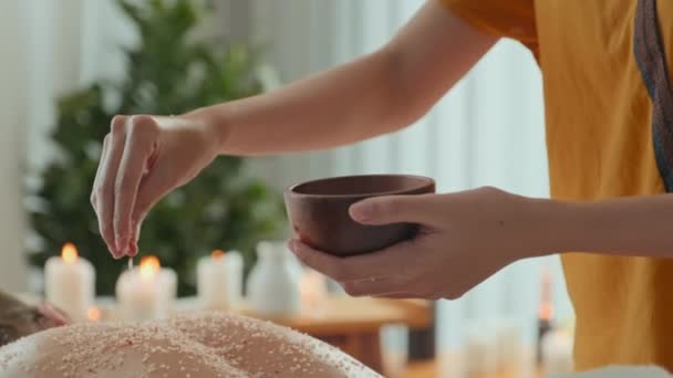 Young beautiful woman enjoying relaxing salt scrub back massage in luxurious spa salon - Video, Çekim