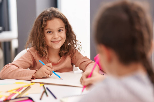 Kaksi lasta istuu pöydällä piirustus kannettavan paperin luokkahuoneessa - Valokuva, kuva