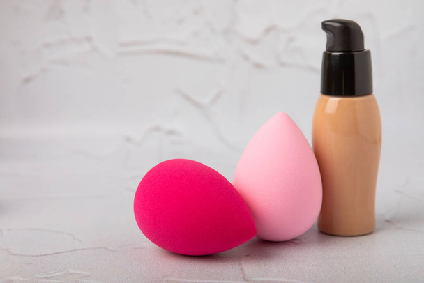 Liquid foundation for makeup and sponge blender for makeup. Foundation beauty face makeup application, perfect makeup tool. Beauty blender,bb cream or concealer on marble texture background. - Foto, Imagen