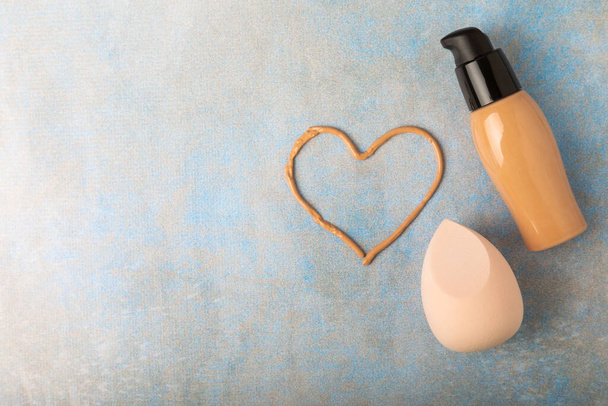 Liquid foundation for makeup and sponge blender for makeup. Foundation beauty face makeup application, perfect makeup tool. Beauty blender,bb cream or concealer on marble texture background. - Photo, Image