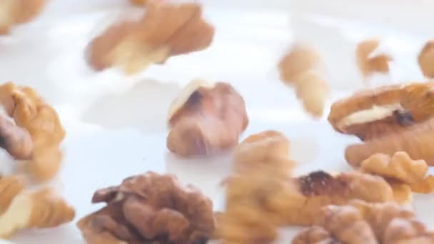 Padají do talíře s ořechy bez skořápky ve velkém množství. Loupaný vlašský ořech. Přírodní produkt. Zpomalený pohyb - Záběry, video