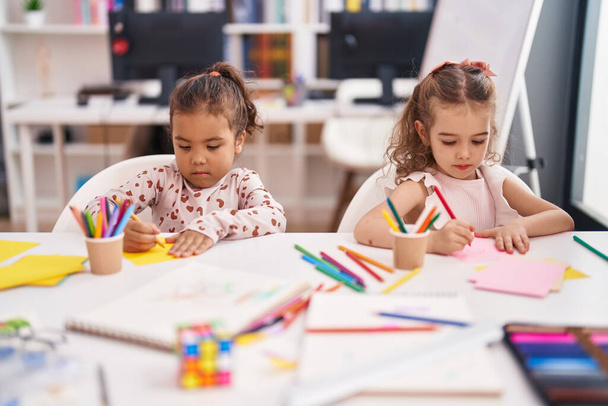 Two kids preschool students sitting on table drawing on paper at classroom - Foto, Imagen