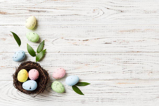 Oeufs de Pâques colorés dans le nid sur fond de table avec vue de dessus de l'espace de copie. - Photo, image