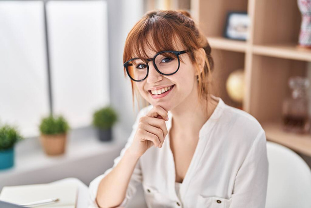 Young woman smiling confident sitting on table at home - Foto, Imagen