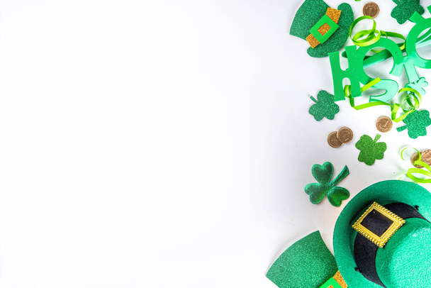 St Patrick holiday flatlay background with shamrock clover leaves, leprechaun hat decor, golden coin, party accessories, symbols of Patrick day - Foto, afbeelding