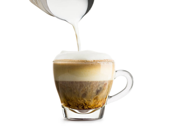 Making cappuccino in glass cup with milk frother on white background. - Fotografie, Obrázek