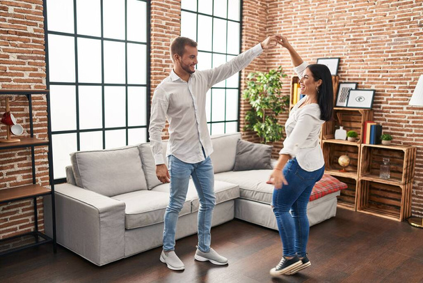 Hombre y mujer pareja sonriendo feliz bailando en casa - Foto, imagen