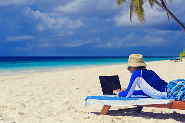 человек с ноутбуком на пляже отдыха
 - Фото, изображение