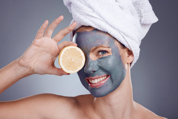 Lemon, face mask and portrait of woman, healthy skincare and beauty of anti aging wellness makeup in studio. Happy female model, citrus fruits and food for vitamin c, aesthetic facial and shower glow. - Fotó, kép