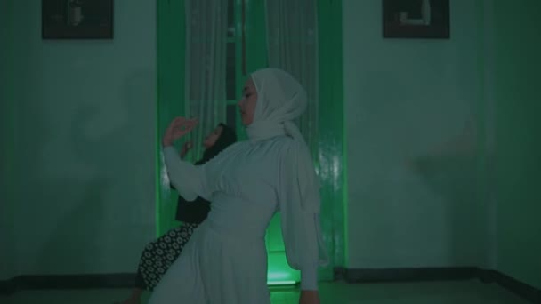 Дві мусульманки в білому і чорному вбранні танцювали разом дуже гнучко в кімнаті. - Кадри, відео