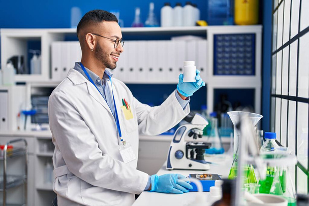 Африканский американец ученый улыбается уверенно взвешивая таблетки в лаборатории - Фото, изображение