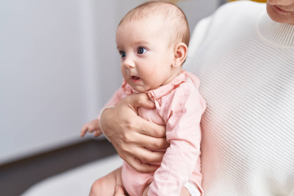 Adorable bebé caucásico en las manos de la madre en casa - Foto, Imagen