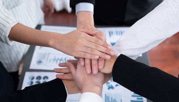 Top view closeup business team of suit-clad businesspeople join hand stack together. Colleague collaborate and work together to promote harmony and teamwork concept in office workplace. - Fotografie, Obrázek