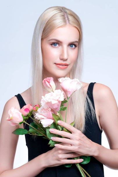 Closeup young personable woman with natural makeup and healthy soft skin holding rose for beauty care advertising in isolated background. Beautiful pretty model girl with flower concept. - Foto, Imagen
