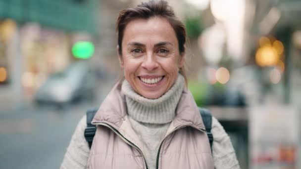 Mujer de mediana edad sonriendo confiada de pie en la calle - Metraje, vídeo