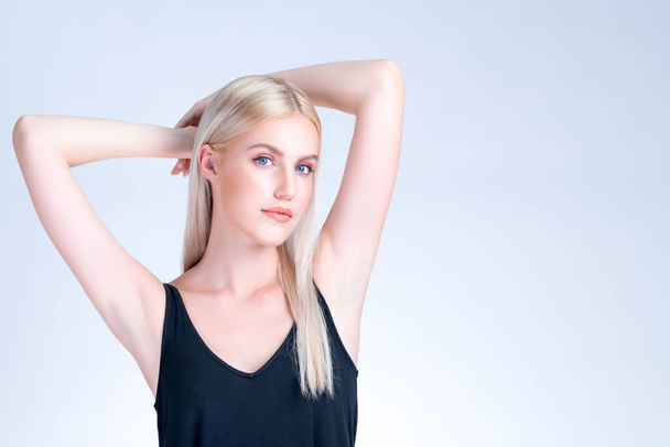 Personable woman lifting her armpit showing hairless hygiene underarm as beauty posing for cleanliness and perfect smooth skincare treatment in isolated background. Hair removal and epilation concept. - 写真・画像