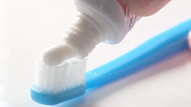 Применение зубной пасты к макровидео с зубной щеткой. Концепция стоматологической помощи. Реклама зубной пасты - Кадры, видео