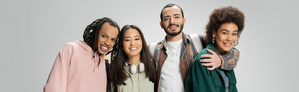 happy multicultural friends in trendy clothes smiling at camera isolated on grey, banner - Foto, Imagen