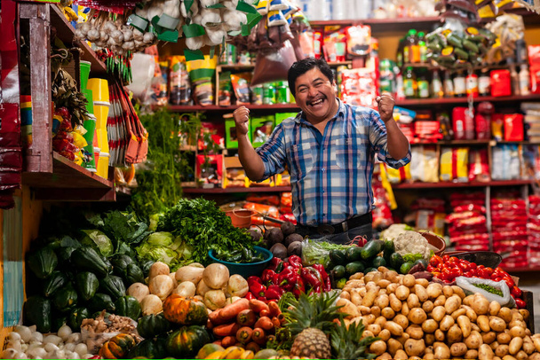 food bazaar in Guatemala, happy latin-american man selling vegetables and fruits    - Valokuva, kuva