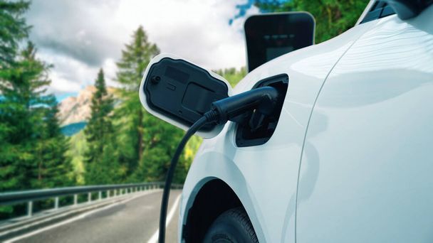 緑の森の充電ステーションから再生可能エネルギーとクリーンエネルギーを動力とする電気自動車の環境意識を高めるための進歩的なキャンペーン。将来の自動車用EV車. - 写真・画像