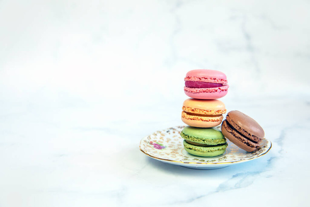 Franse kleurrijke Macarons Kleurrijke Pastel Macarons op witte achtergrond pastel roze en bruine Macaron met verse bosbes, zoete cake stapel kopieer ruimte snack - Foto, afbeelding