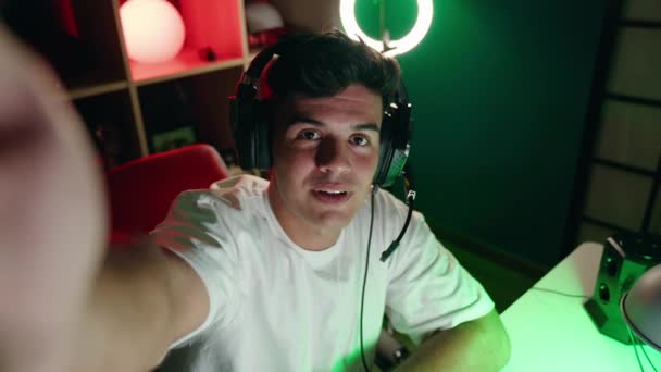Jeune homme hispanique banderole souriant confiant ayant appel vidéo à la salle de jeux - Séquence, vidéo