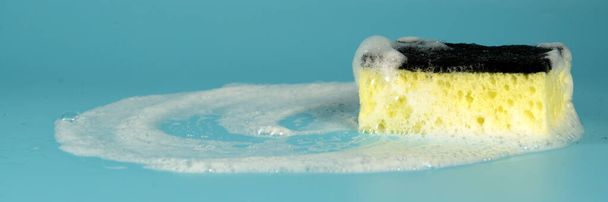 Multicolored sponges for washing dishes and other household needs. The sponges lie on a blue background at a slight angle. Cleaning and Dishwashing Concept - Photo, image