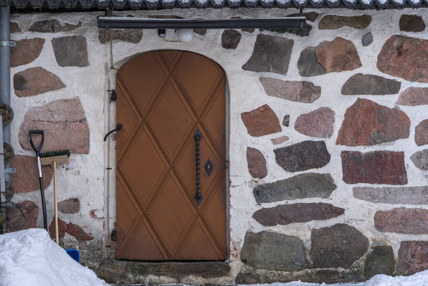 Fa ajtó középkori kő templom télen. - Fotó, kép