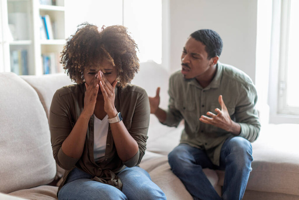 Abusive black husband arguing yelling blaming crying wife of problems, jealous distrustful dominant african american boyfriend controlling shouting at sad girlfriend, Domestic violence, abuse concept - Foto, Imagem