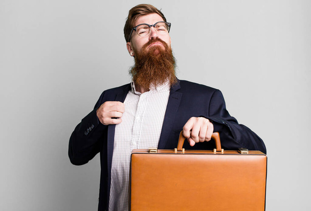 jovem adulto cabelo vermelho barbudo legal empresário com uma mala de couro - Foto, Imagem
