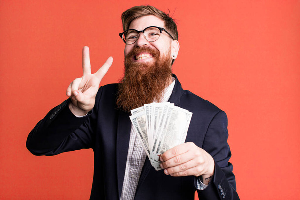 young adult red hair bearded cool businessman with dollarbanknotes - Φωτογραφία, εικόνα