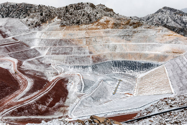 View of the industrial mine waste dam (tailing dam). A tailings dam is typically an earth-fill embankment dam used to store byproducts of mining operations after separating the ore from the gangue. - 写真・画像