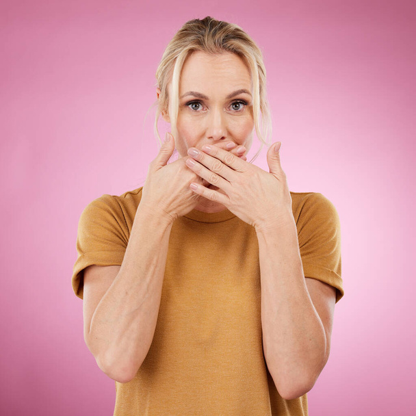 Secret, studio and woman with her hand on her mouth with a shock, surprise or quiet face expression. Gossip, shocked and portrait of a female model with surprised gesture isolated by pink background - 写真・画像