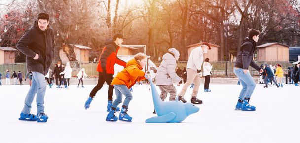 04.01.2022.Budapest.Winter sports.Family winter sport.Holiday and seasonal concept.Activity,Adult,Child,Childhood, Daughter.Happy little boy and girl learning to skate in winter.Hobbies and Leisure. - Fotoğraf, Görsel