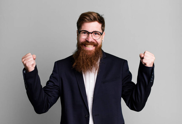 homem barba longa sentindo-se chocado, rindo e celebrando o sucesso. conceito de negócio - Foto, Imagem