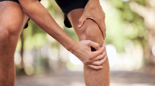 Knee pain, hands and legs injury at park after training, workout or exercise accident. Sports, fitness and man or runner with fibromyalgia, inflammation or arthritis after .exercising, running or jog. - Fotografie, Obrázek