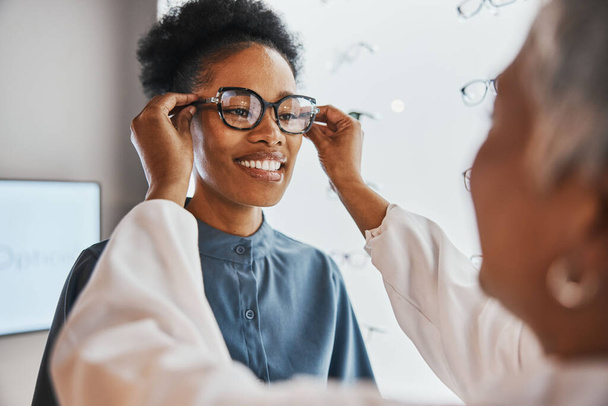 Glasses check, black woman and customer with store worker and optician looking at lense. Eye consulting, smile and eyewear assessment in a frame shop for vision test and prescription exam for eyes. - Foto, Bild