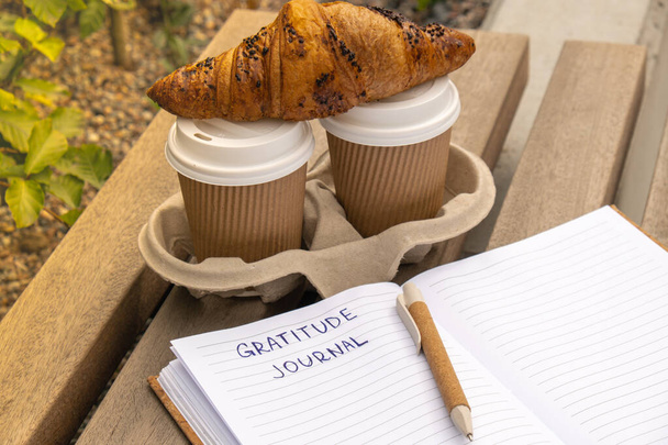 Dankbaarheid Journal schrijven op houten bank. Koffie en croissants ochtendroutine. Daar ben ik vandaag dankbaar voor. Zelfontdekking tijdschrift, zelfreflectie creatief schrijven, zelfgroei persoonlijke ontwikkeling concept. Zelfzorg welzijn geestelijke gezondheid, zijn - Foto, afbeelding