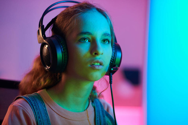 Εφηβική κοπέλα που διαβάζει τις απαιτήσεις τουρνουά βιντεοπαιχνιδιών στην οθόνη του υπολογιστή - Φωτογραφία, εικόνα