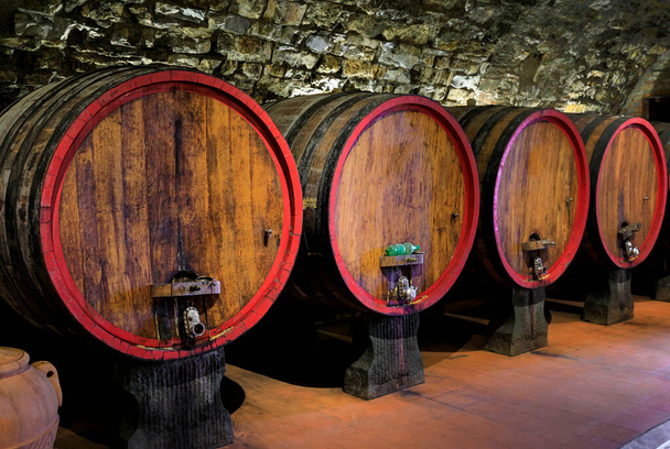 Chianti wine from Sangiovese grapes aging in wooden barrels at a vineyard in the famous wine producing Chianti Classico Region of Tuscany, Italy - Foto, Imagen
