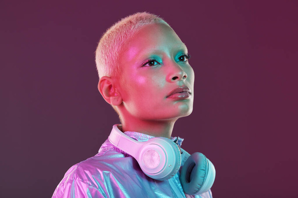 Cyberpunk fashion, black woman and headphones in studio, holographic clothes and vaporwave style. Futuristic model, young gen z and listening to music with retro aesthetic, audio technology and neon. - Foto, Imagem